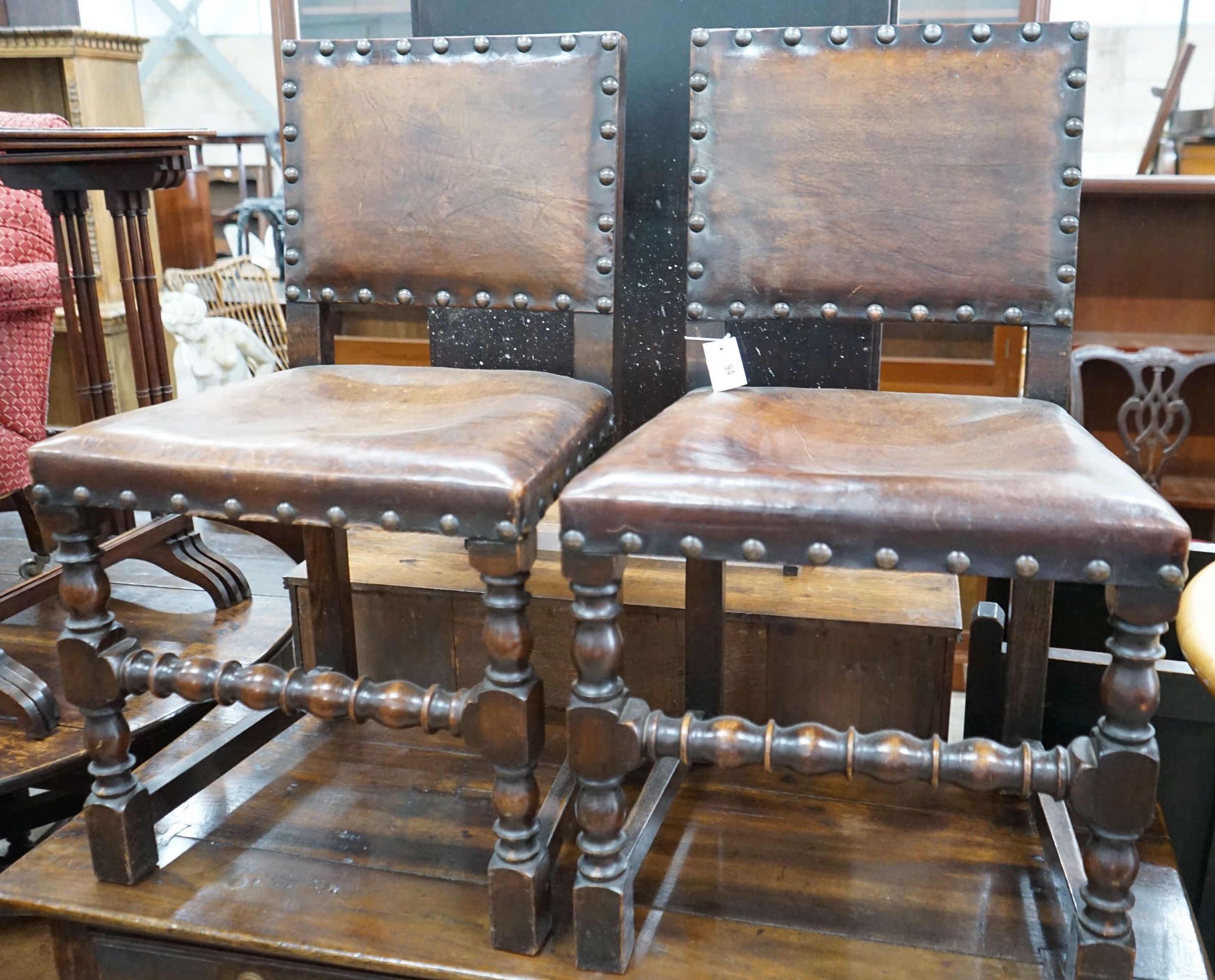 A set of six Carolean style oak and studded leather dining chairs